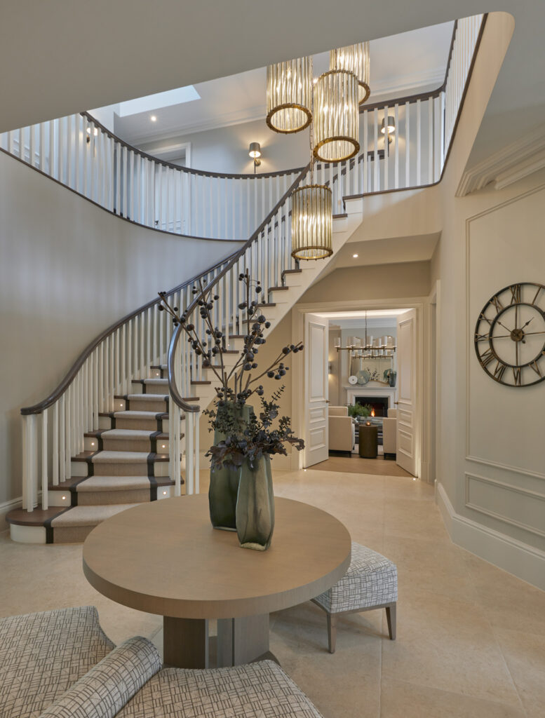 Grand entrance hall designed by Hill House Interiors showing layered materials and considered furniture placement to create warmth at scale